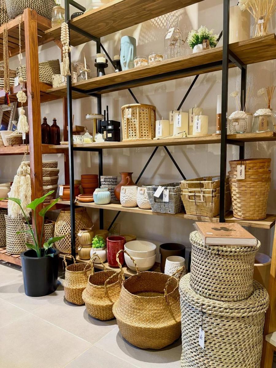 Estanterías de madera del local de Arcos Home con cestos, velas y vajilla